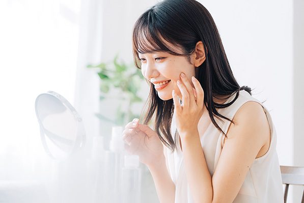 鏡でお肌のチェックをする笑顔の女性